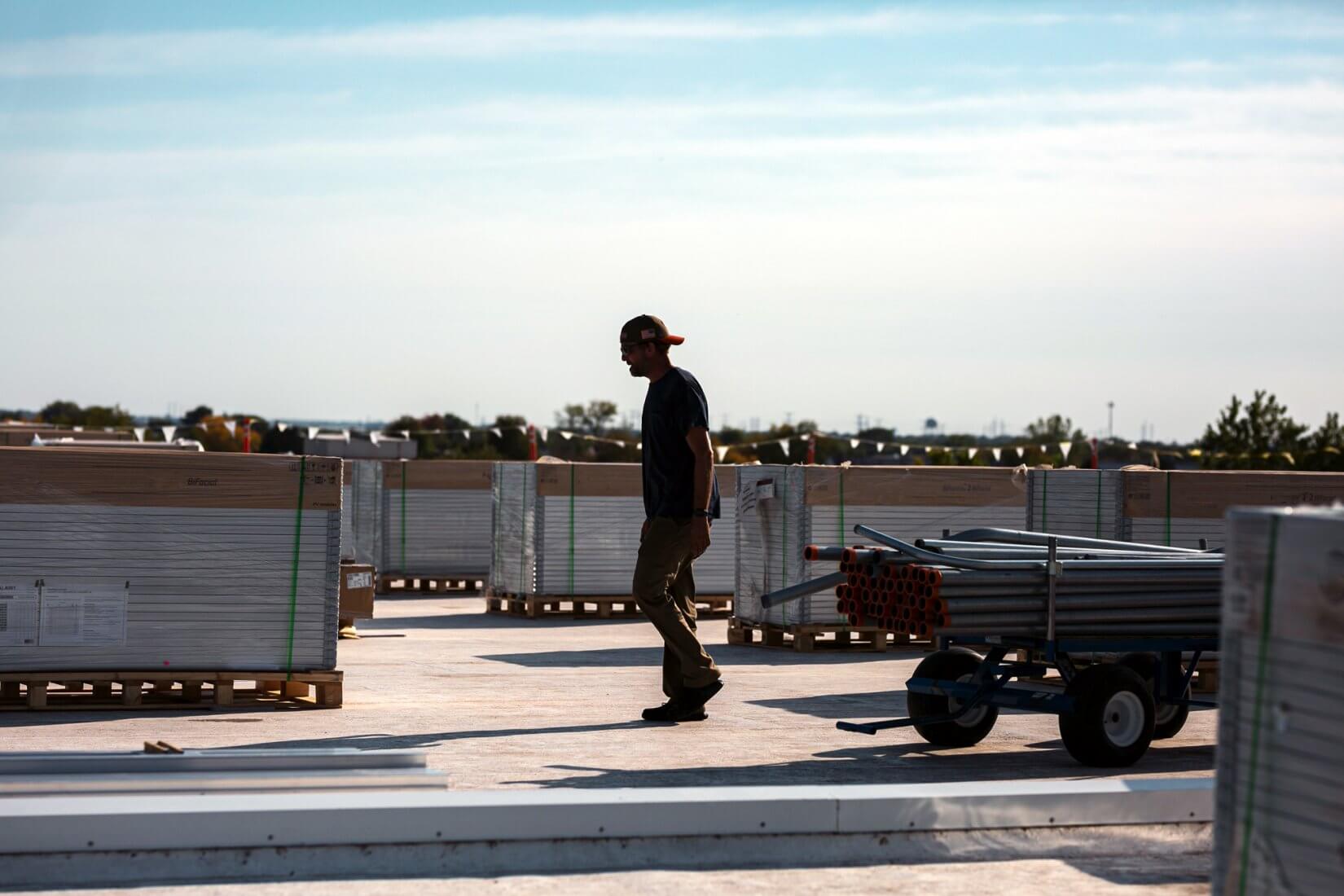 A man walking at the rooftop with solar panels