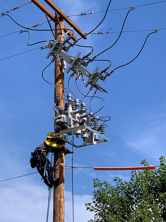 Engineer working on sensor on a power line.