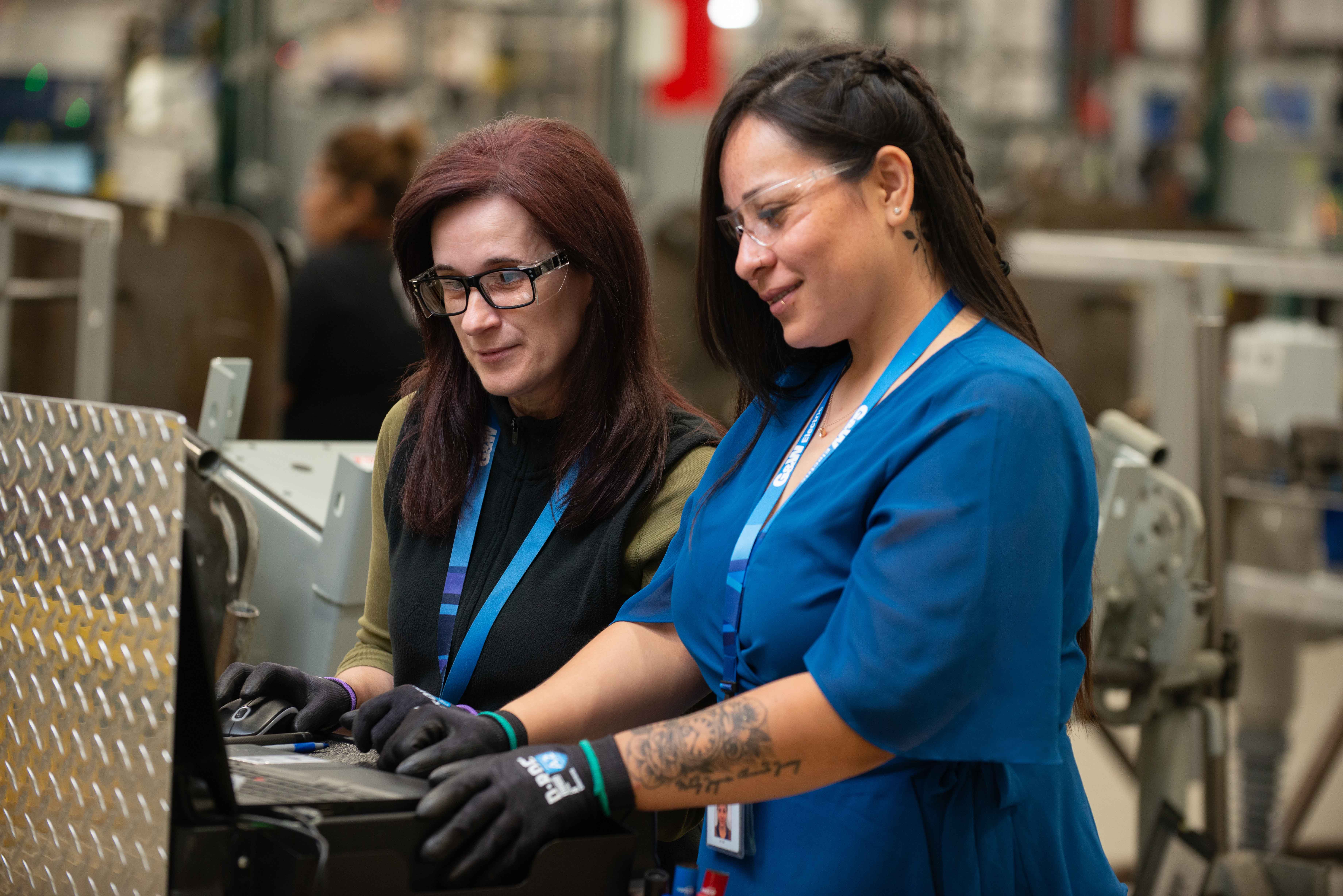 Two women working on a device together