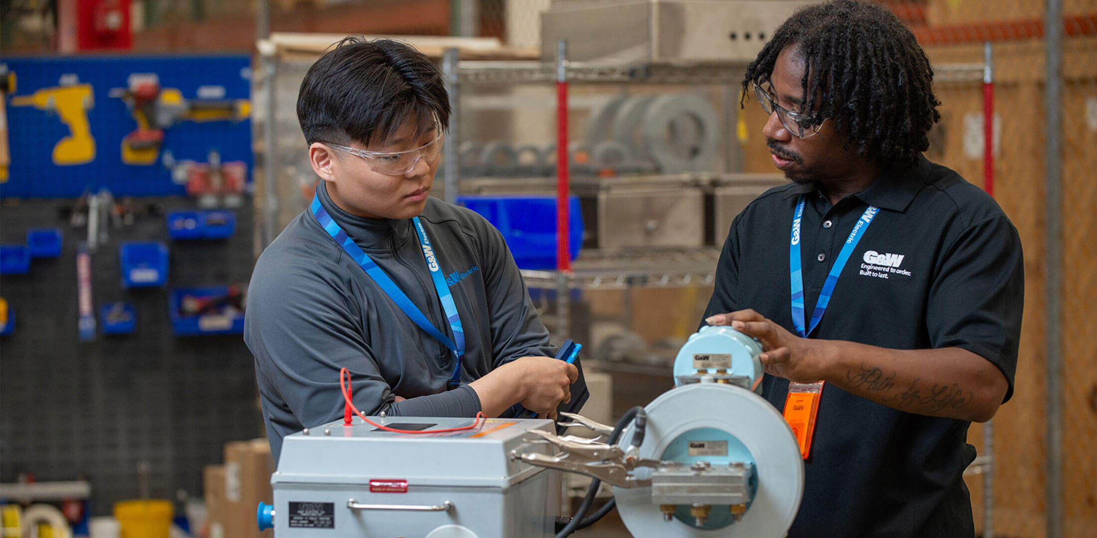 Two employees working on a machine together